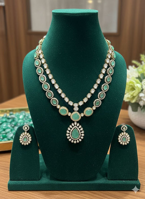 Jewelry set with necklace and earrings on a green mannequin bust