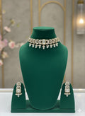 Jewelry set with necklace and earrings on a green mannequin bust.